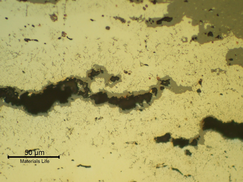 Micrographic detail of the creep voids and interconnected cracks. The broken bolt remained in service during some time and the fracture surface presented a thick oxide layer(grey). As polished.
