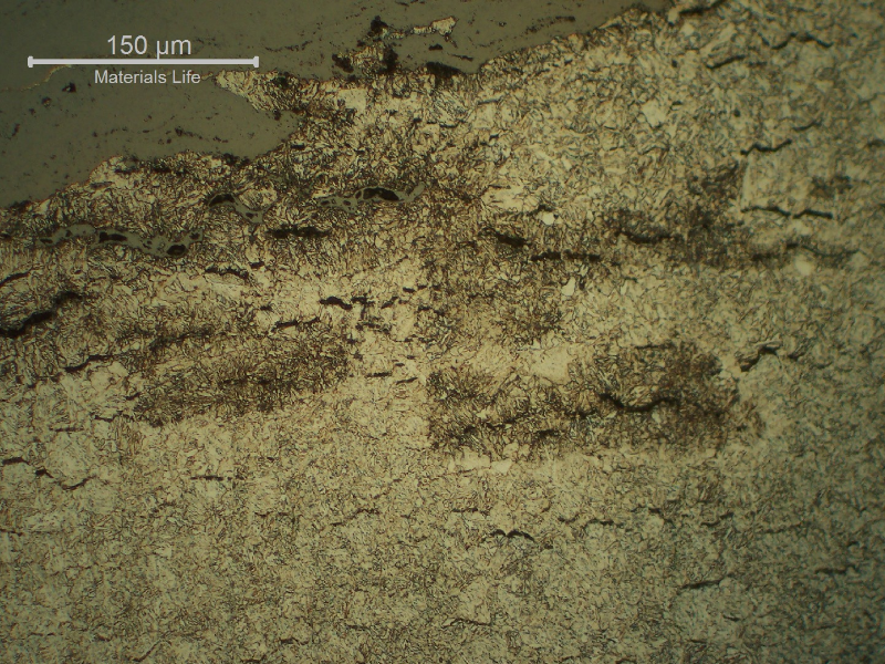 Micrography of a longitudinal section of a CrMov steel bolt that broke in service by a creep mechanism in a gas turbine. Tempered structure. Interconnected  cracks paralled to the fracture surface.