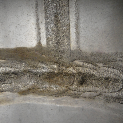 Internal aspect of the 8" diameter pipe that suffered localized thinning and leakage.  The vertical weld is the pipe seam and the horizontal weld is the circunferential butt weld.
