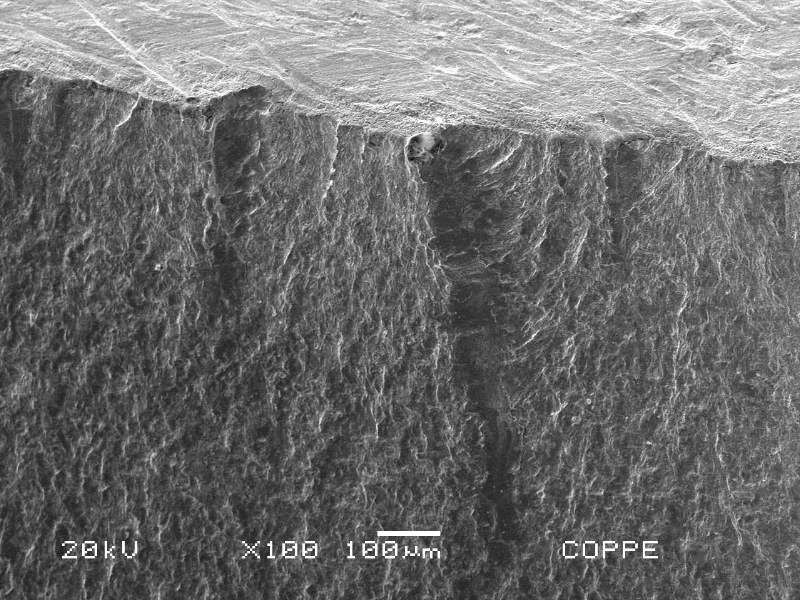 The fracture surface of the main pipe is presented in low magnification (external pipe surface in the top) showing a flat propagation starting from the contour of the weld margin.