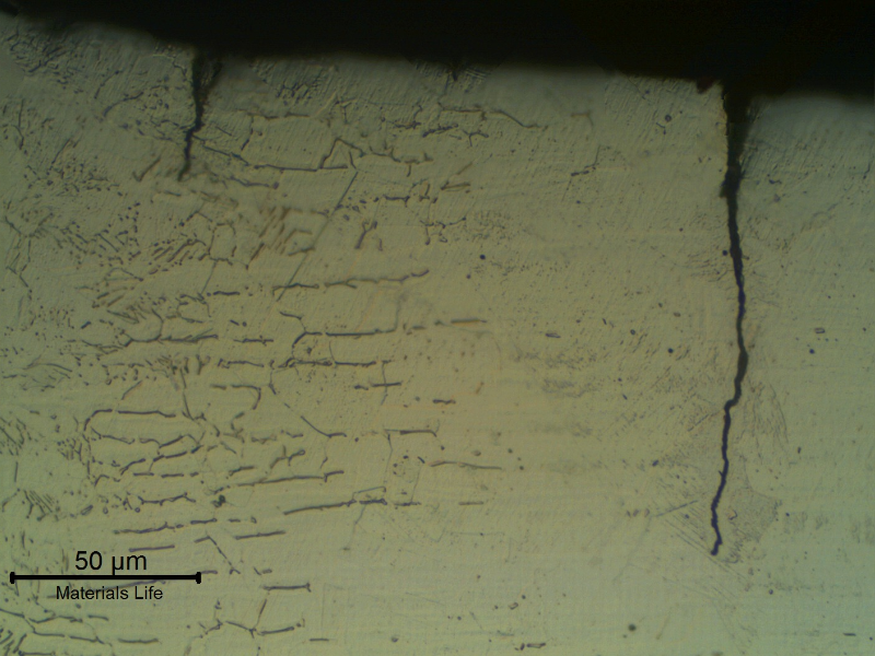 Micrography of the section transverse to the weld and in a region close to the fracture surface (to the right side of the figure).  The secondary fatigue microcracks are associated to the stress concentration raisers of the margin of the weld, irregular.