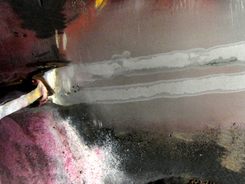 The internal surface of the 2 1/2" thickness plate drum was welded to attach a baffle plate (1/4" thick) using two fillets (one in each side of the plate to shell), but the welding procedure was not suitable since cracks appeared underbead, although they were detected only after 6 month in operation, when the baffle was removed. The picture shows a macrography of the surface, with the cracking.