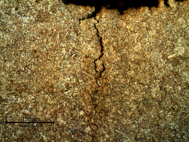 Micrography of a longitudinal section of the pin, at the fracture position, showing the main fracture surface and secondary cracks associated to a segregation band, with an intergranular morphology.
