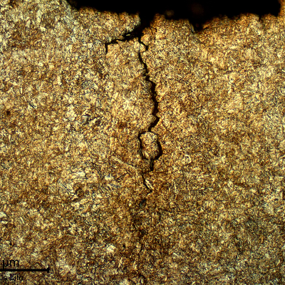 Micrography of a longitudinal section of the pin, at the fracture position, showing the main fracture surface and secondary cracks associated to a segregation band, with an intergranular morphology.