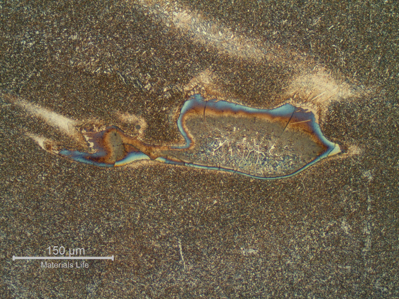 Detail of a region of entrapped carbon from the arc gouging, in the weld metal.