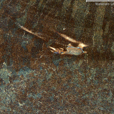 Low magnification micrography of the weld metal, evidencing regions of low dilution of the entrapped carbon from the arc gouging.