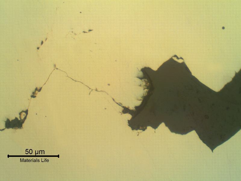Transverse section of the fitting that suffered a longitudinal cracking. As polished. The wrought fitting has suffered intergranular stress corrosion cracking from the internal surface, exposed to hot caustic environment.