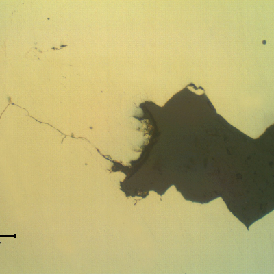 Transverse section of the fitting that suffered a longitudinal cracking. As polished. The wrought fitting has suffered intergranular stress corrosion cracking from the internal surface, exposed to hot caustic environment.