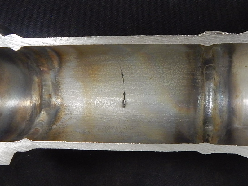 Aspect of the internal surface of the pipe after longitudinal cutting, presenting a straight cracking, circumferential. The weldolet is to the left side and the flange is to the right side. See the schematic drawing in the next figure.