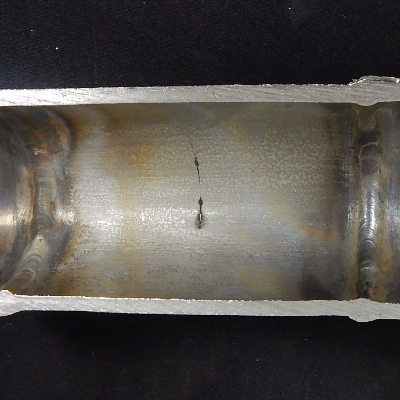 Aspect of the internal surface of the pipe after longitudinal cutting, presenting a straight cracking, circumferential. The weldolet is to the left side and the flange is to the right side. See the schematic drawing in the next figure.