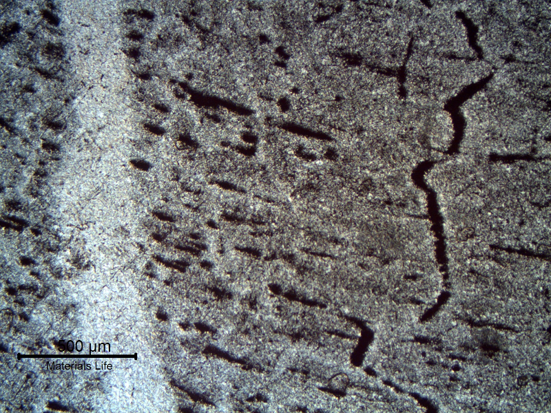 Welded region etched to reveal impurities. The banded structure creates a continuous network parallel to the weld metal.