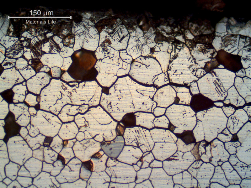 Micrographic aspect of a longitudinal section of the plate, close to the surface, in a region with intergranular corrosion. Several loose grains were removed, indicating that the structure was embrittled by the intergranular corrosion.