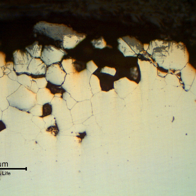 The micrography of the transverse section of the plate, as polished, close to the surface. The material presents intergranular corrosion and some grains were lost.