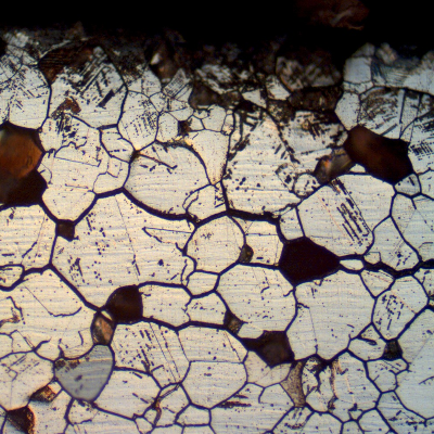 Micrographic aspect of a longitudinal section of the plate, close to the surface, in a region with intergranular corrosion. Several loose grains were removed, indicating that the structure was embrittled by the intergranular corrosion.