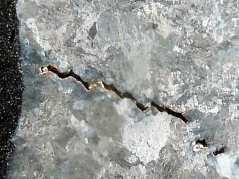 Linear indication in the sample, after metallographic preparation.  The "cracking" is a casting defect.