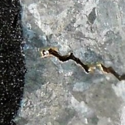 Linear indication in the sample, after metallographic preparation.  The "cracking" is a casting defect.