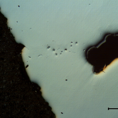 Micrographic detail of the defect (void in the right side of the figure), as polished.  In the left side it is the surface of the water blade and there are some non metalic inclusions in this region.