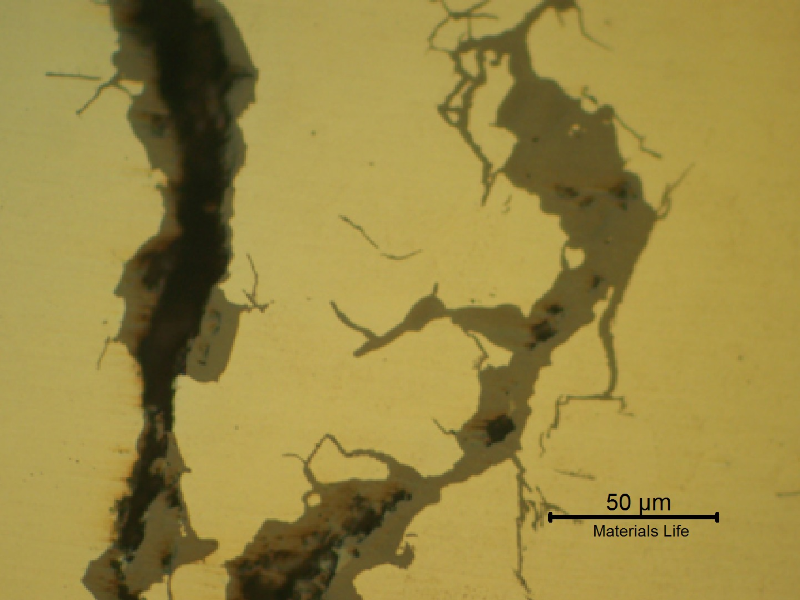 Micrographic detail of a crack, in a sample as polished, presenting regions of opened cracks and filled cracks.