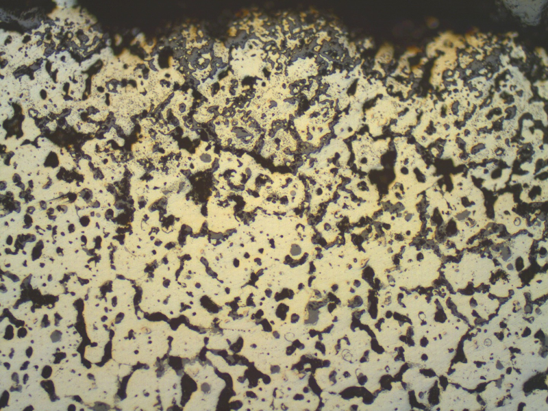 Micrography, in the as polished condition, of the TUBE REMOVED FROM SERVICE, centrifugally cast, in the transverse section, presenting external surface oxides and voids.