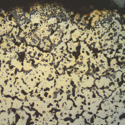 Micrography, in the as polished condition, of the TUBE REMOVED FROM SERVICE, centrifugally cast, in the transverse section, presenting external surface oxides and voids.
