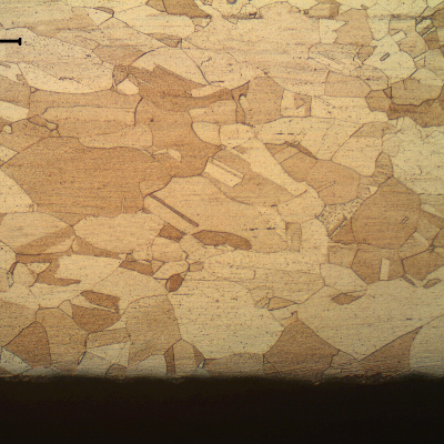 The material structure is similar all through the thickness and there are no evidencies of corrosion at the surfaces.