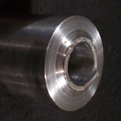 Aspect of the broken shear pin that was manufactured in a martensitic stainless steel forged bar, machined with the external diameter of 50mm, the internal diameter of 20mm and the shearing diameter of 25mm (shearing thickness 2.5mm). The fracture, in the right side of the figure, is not fully flat as should be expected for a shearing mechanism.