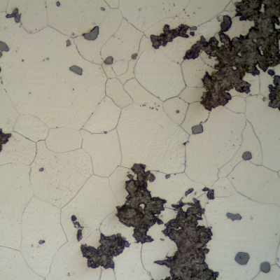 Detail of CAP A microstructure. Graphite in imperfect nodules and ferritic matrix. Grey sulphide inclusions.