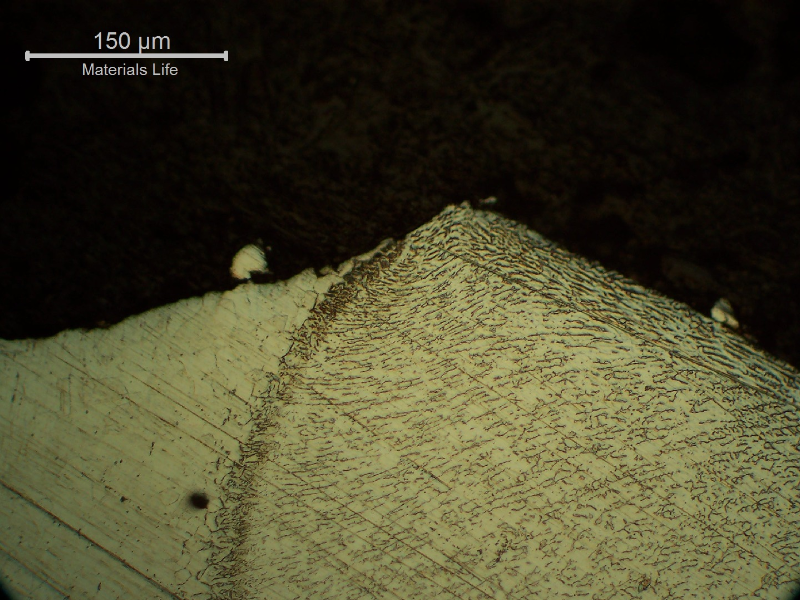 The micrography of the welded joint between the flange and the shell, in a region that was through wall cracked, the fracture propagating in the shell plate base metal.