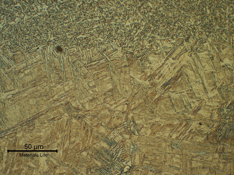 Micrography of the low carbon steel plate at the fusion line, presenting a bainitic structure at the HAZ and ferritic structure in the weld metal.