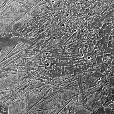 Micrographic detail of the fusion line of the carbon steel plate, by scanning electron microscopy, showing the bainitic structure at the HAZ and ferritic structure in the weld metal.