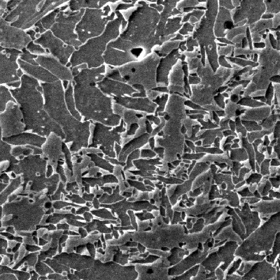 Micrographic detail of the ferritic structure in the weld metal close to the carbon steel plate, by scanning electron microscopy.  The weld metal presents a typical aspect for low strenght weld metal (grain boundary and primary ferrite, plus acicular ferrite).