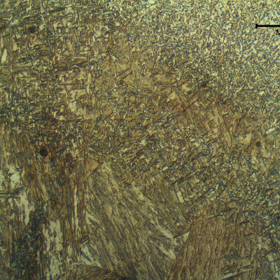 Micrography of the low alloy steel tube at the fusion line, presenting a martensitic structure at the HAZ and acicular ferrite in the weld metal.