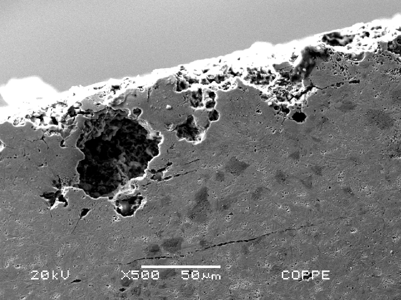 Micrographic aspect of the pitting corrosion at the knife surface. It is possible to see the typical pitting aspect of a localized corrosion that appears as a small dot at the surface but it is a big crater under the surface.