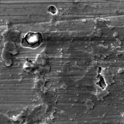 Detail of the rusted surface. EDS analysis inside the pitting shows a high Cl peak (the bright aspect inside the pitting), indicating that the salt over the surface was responsible for destroying the passive layer and the localized corrosion occurred.