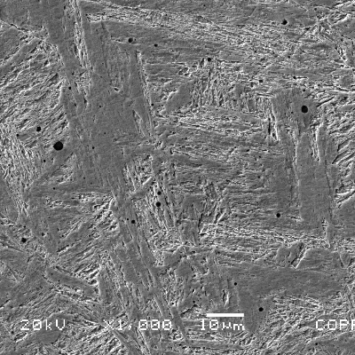 Micrographic detail of the weld metal presenting equiaxial grains grains and martensitic structure. There are also multiples globular inclusions, caracteristic of a welding process that uses flux.