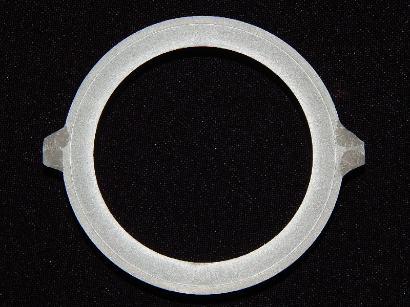 The macrography of a transverse section shows the carbon steel tube, externally cladded with stainless steel.  The tube was removed from service where it was welded to other tubes to form a wall.