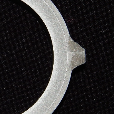 The macrography of a transverse section shows the carbon steel tube, externally cladded with stainless steel.  The tube was removed from service where it was welded to other tubes to form a wall.