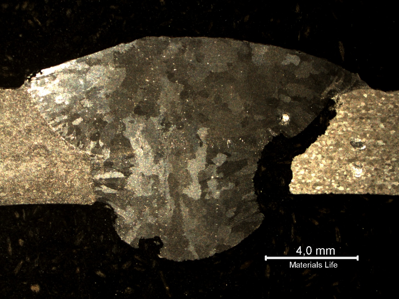 The macrography of the welded joint shows the AA 6063 alloy pipe in the right and the AA 3003 pipe in the left, welded in two passes. The root presents small regions of corrosion in the weld metal and a localized corrosion at the fusion line of the 6063 pipe (knife-line attack morphology).