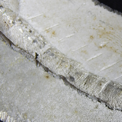 Internal surface detail of the 3 1/2" pipe, cut in a longitudinal section (transverse to the weld), presenting a localized corrosion at the margin of the welded joint (Keller etched), in the root.  The pipeline was assembled with pipes manufactured in two different aluminum alloys, AA 3003 (top of the figure) and AA 6063 (bottom of the figure), and the localized corrosion occurred at the fusion line of the 6063 pipe.