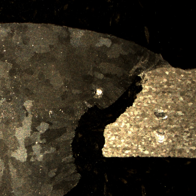 The macrography of the welded joint shows the AA 6063 alloy pipe in the right and the AA 3003 pipe in the left, welded in two passes.  The root presents small regions of corrosion in the weld metal and a localized corrosion at the fusion line of the 6063 pipe (knife-line attack morphology).