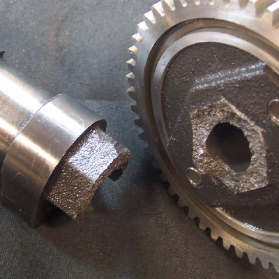 The camshaft broke in a brittle way in a region where the shaft changed the geometry, close to a chilled lobe.