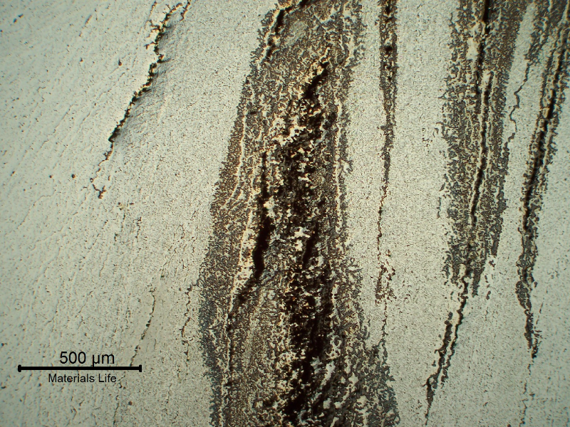 Micrography of a transverse section of the seam weld, in the middle of the thickness, presenting several parallel cracks.
