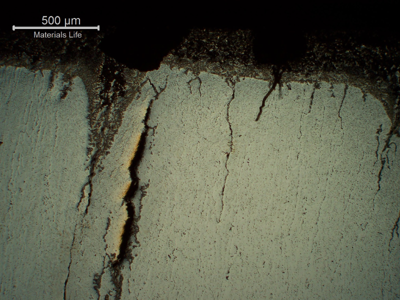Micrography of a transverse section of the seam weld, close to the external surface, presenting several cracks perpendicular to the thickness.