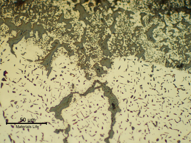 Micrographic detail of the seam weld close to the external surface, presenting the needles that are the result of microstructural evolution and cracks filled with oxides.