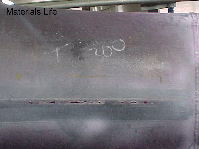 Aspect of the cracking after Dye Check Test (Liquid Penetrant) in the external side of the line that operates at 800°C, insulated, and presented the leakage associated to the longitudinal seam weld of the fitting. The circumferential butt weld of the fitting to a pipe did not fail. See the schematic drawing in the next figure
