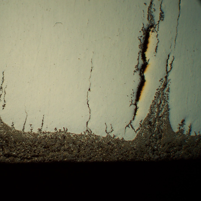 Micrography of a transverse section of the seam weld, close to the internal surface, presenting several cracks perpendicular to the thickness.