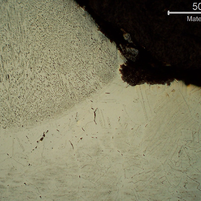 Micrography of a transverse section of the circumferential butt weld, close to the external surface, presenting a shallow localized corrosion at the margin of the weld.