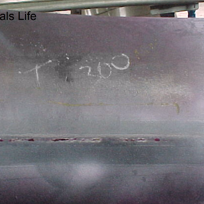 Aspect of the cracking after Dye Check Test (Liquid Penetrant) in the external side of the line that operates at 800°C, insulated, and presented the leakage associated to the longitudinal seam weld of the fitting. The circumferential butt weld of the fitting to a pipe did not fail. See the schematic drawing in the next figure