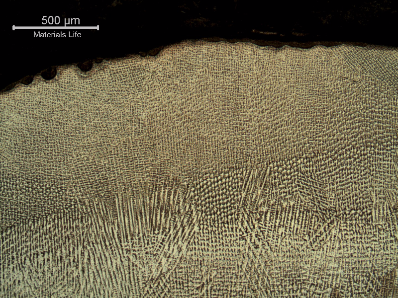 Micrography of the weld metal in the cap pass. A reheated pass is visible at the bottom.