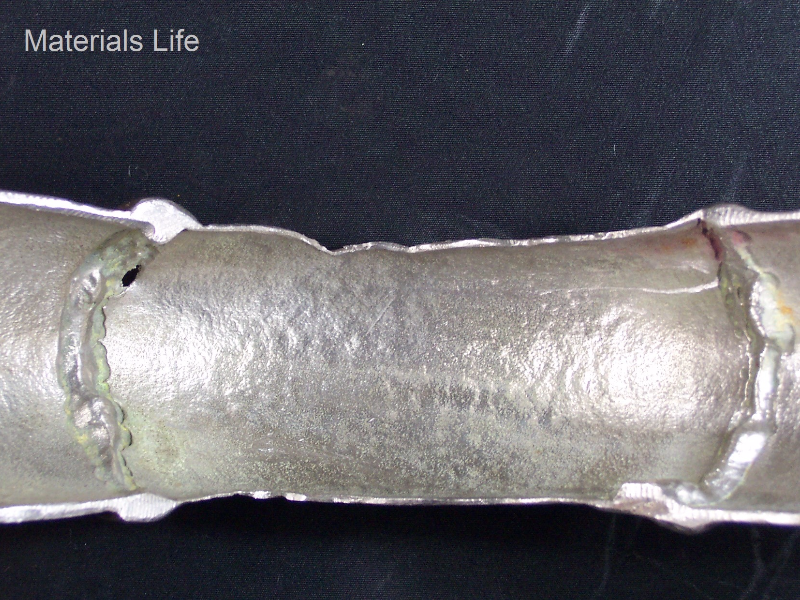 Aspect of the piping cut in the longitudinal direction, presenting the leakage region close to the welded joint between the pipe and the 90° elbow. The original SCH 40 (3.7 mm thickness) presents an actual average thickness of 2 mm all through the piping extension, evidencing a general thinning. See the schematic drawing in the next figure.
